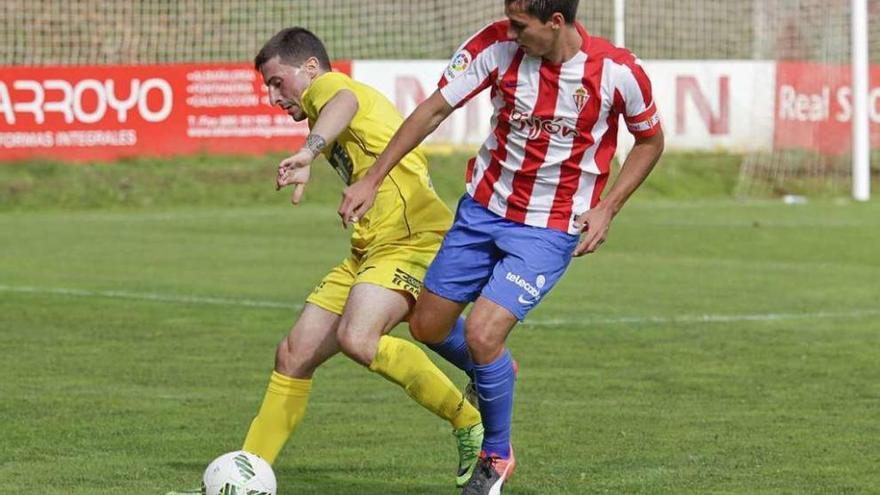 El sportinguista Jaime Santos intenta robarle el balón a un futbolista del Praviano.