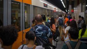 Archivo - Viajeros suben a un tren en uno de los andenes de la estación de Sants