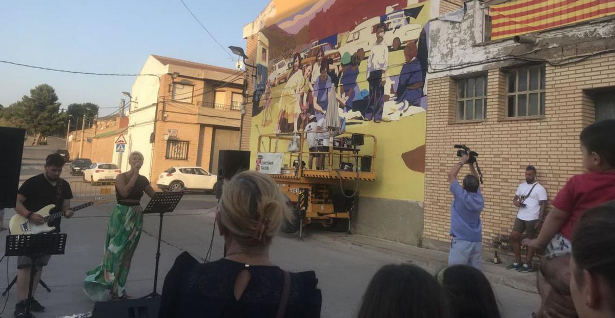 Actuación musical frente a uno de los murales en proceso de creación. | SERVICIO ESPECIAL