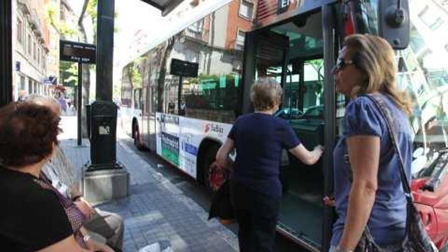 Usuarias del transporte público de Alcoy en una de las marquesinas de la ciudad.