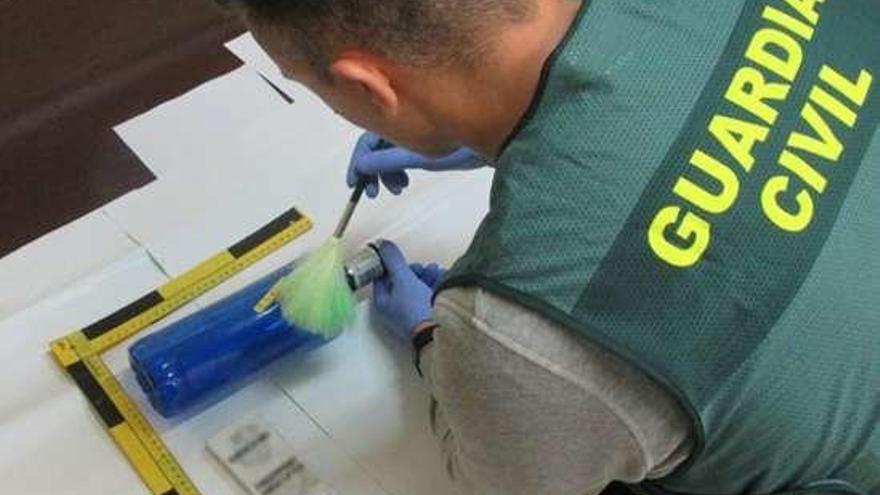 Un investigador analiza las huellas dactilares.  // Guardia Civil