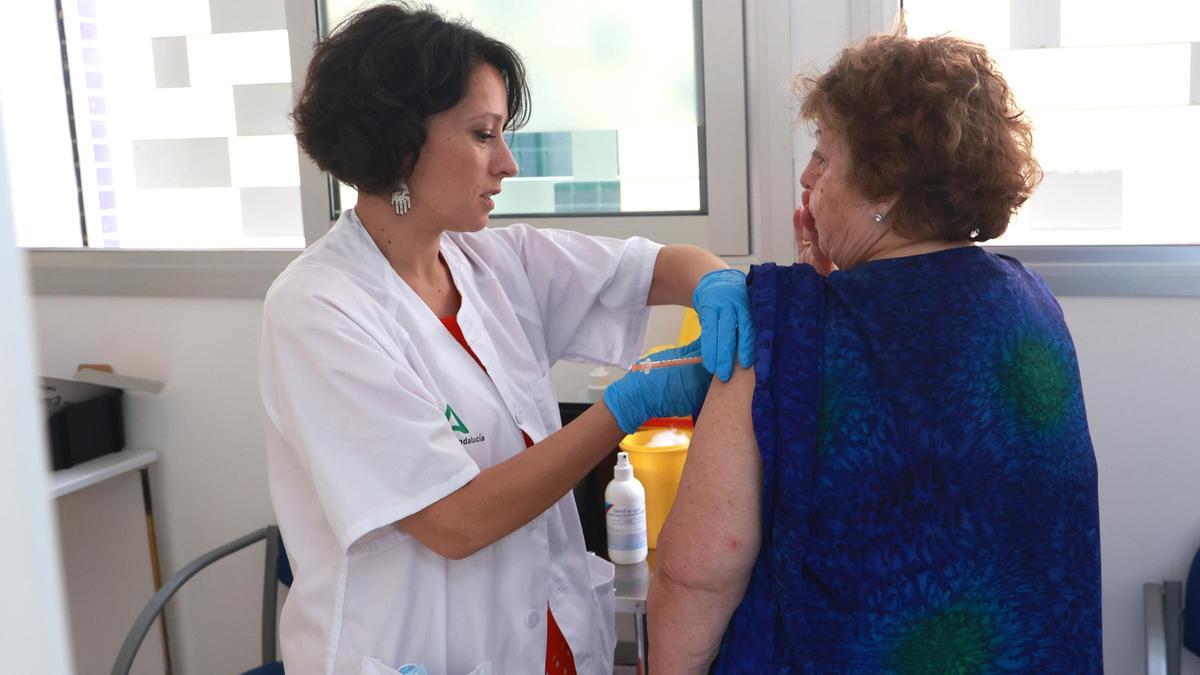 Una mujer recibe la vacuna del covid y la gripe.