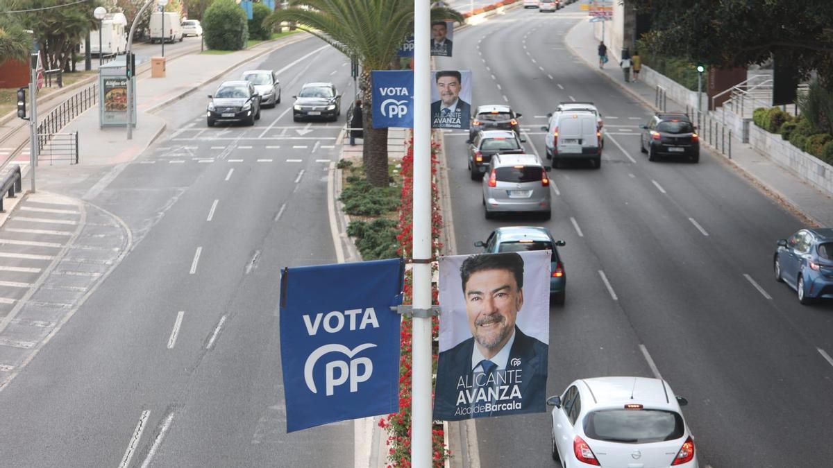 Banderolas en farolas, frente al Postiguet, de las que se tienen que retirar por incumplir la ley