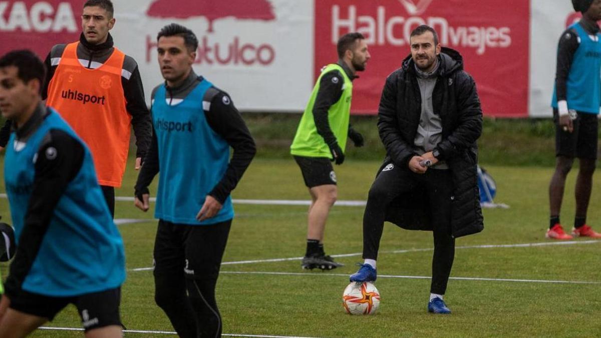 Yago Iglesias, con un balón en sus pies, observa a sus jugadores durante su primera sesión en el Zamora CF.