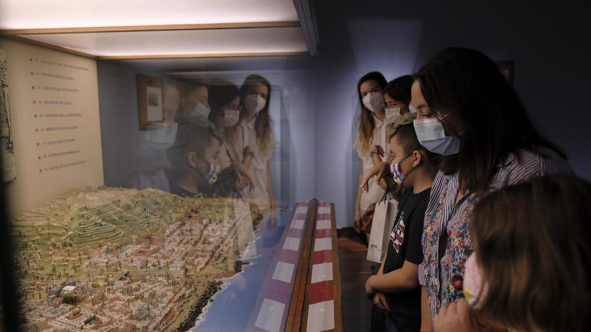 Varias personas observan una maqueta de la ciudad en la Casa de Colón