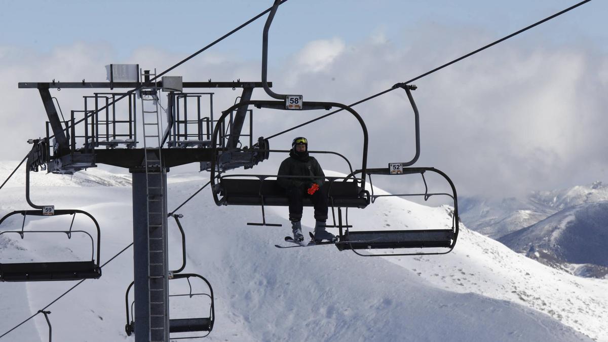 Un esquiador en el telesilla cuiatriplaza de Valgrande-Pajares, el primer día de campaña.