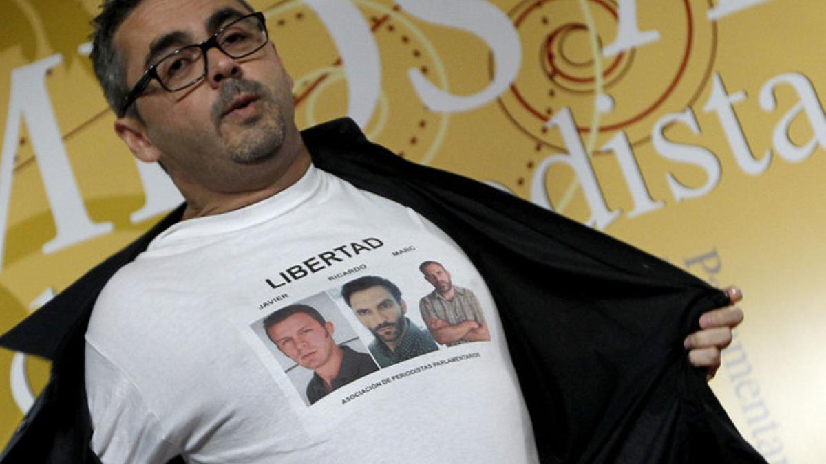El periodista Antonio Montilla muestra una camisa con las fotos de los periodistas secuestrados en Siria, Marc Marginedas, Javier Espinosa y Ricardo Garcia Vilanova, durante la cena de la Asociacion de Periodistas Parlamentarios. JOSE LUIS ROCA