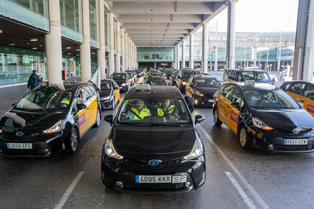 Los taxistas en la zona de carga de pasajeros de la Terminal 1