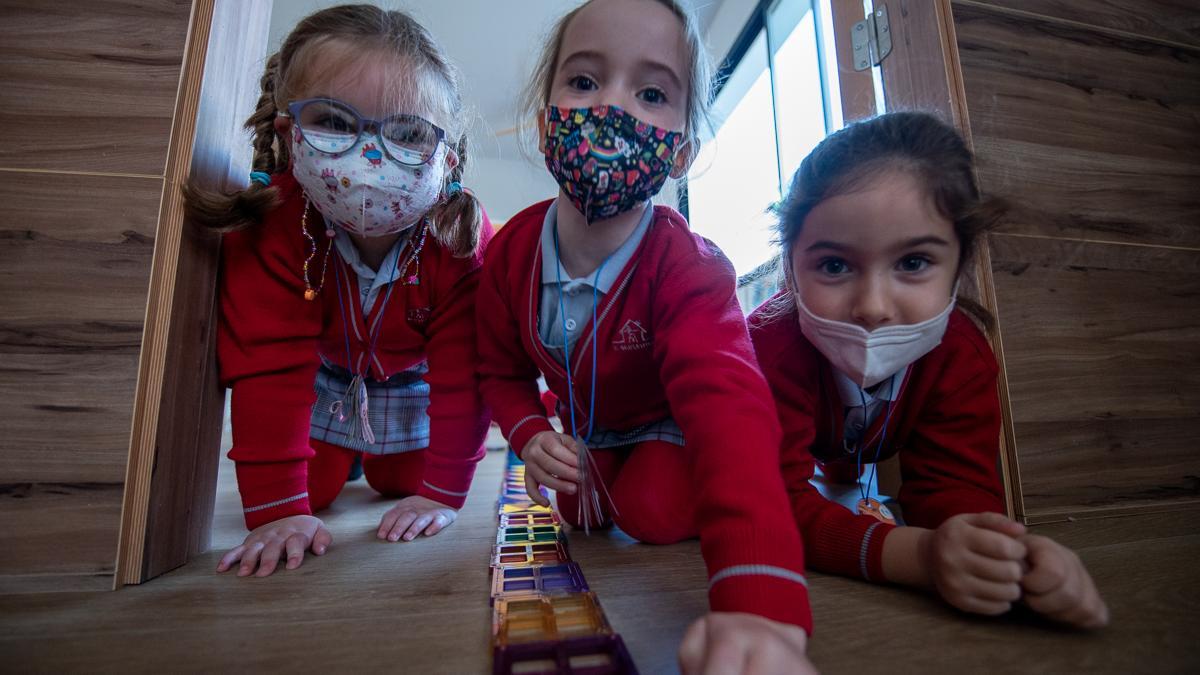 Un grupo de alumnas crea una vía del tren con piezas imantadas que sale hasta el pasillo