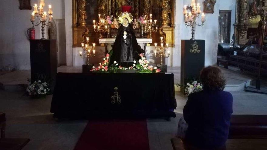 Una mujer observa la imagen de la Virgen de la Soledad en la iglesia de Santa Catalina.