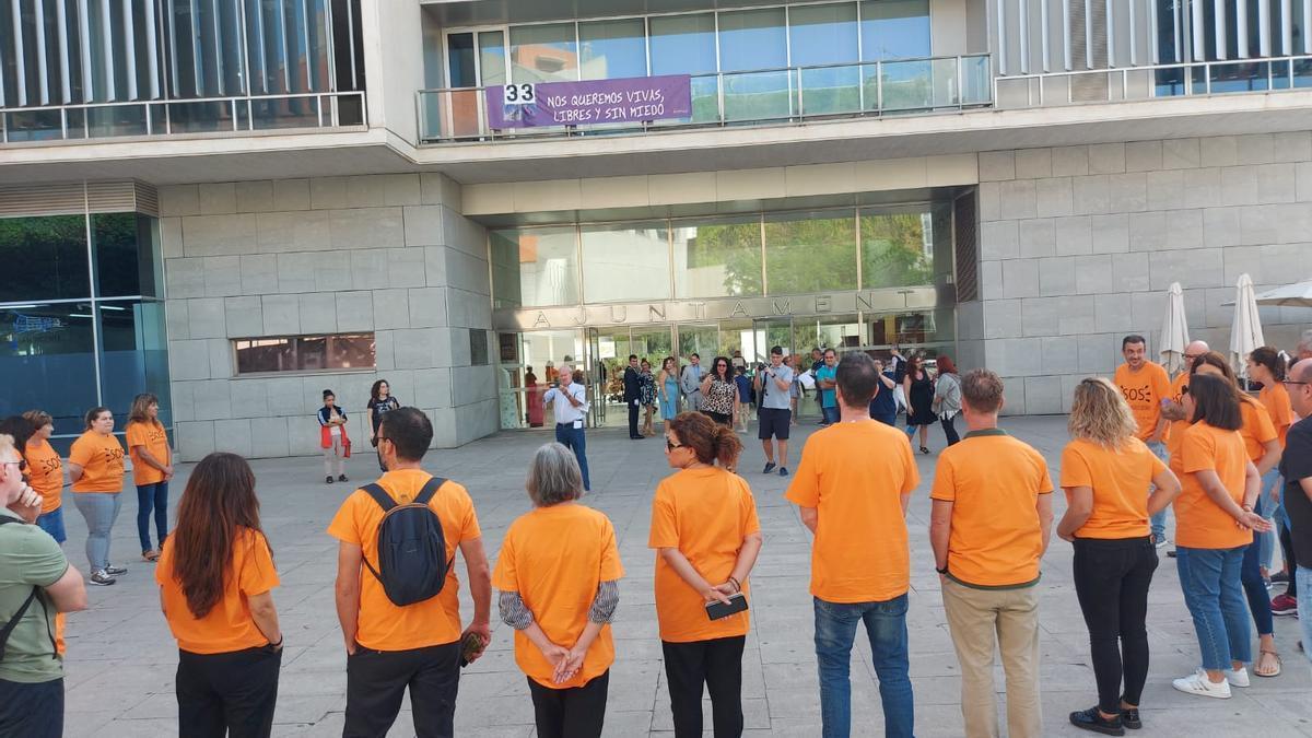 Vestidos con camisetas naranja frente al ayuntamiento para protestar por la precariedad.