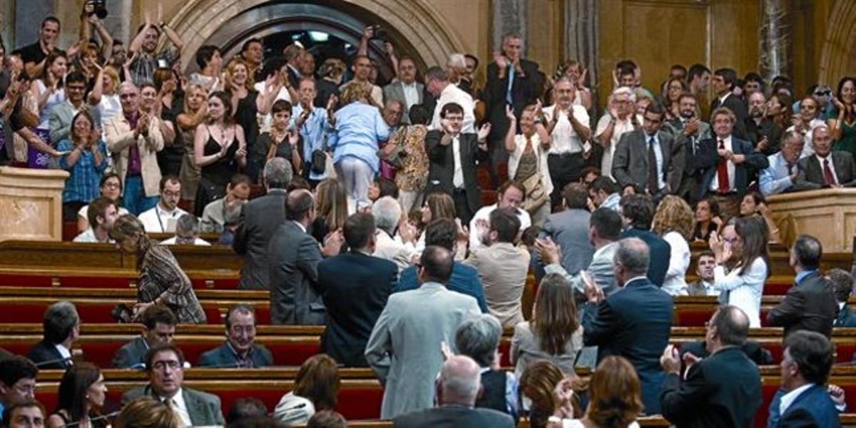 Alguns diputats (en primer terme) i desenes de simpatitzants de la causa antitaurina (al fons, drets) celebren el resultat de la votació, ahir.