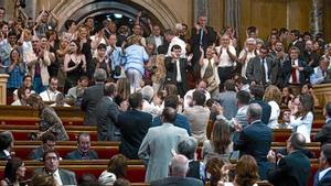 Algunos diputados (en primer término) y decenas de simpatizantes de la causa antitaurina (al fondo, de pie) celebran el resultado de la votación, ayer.