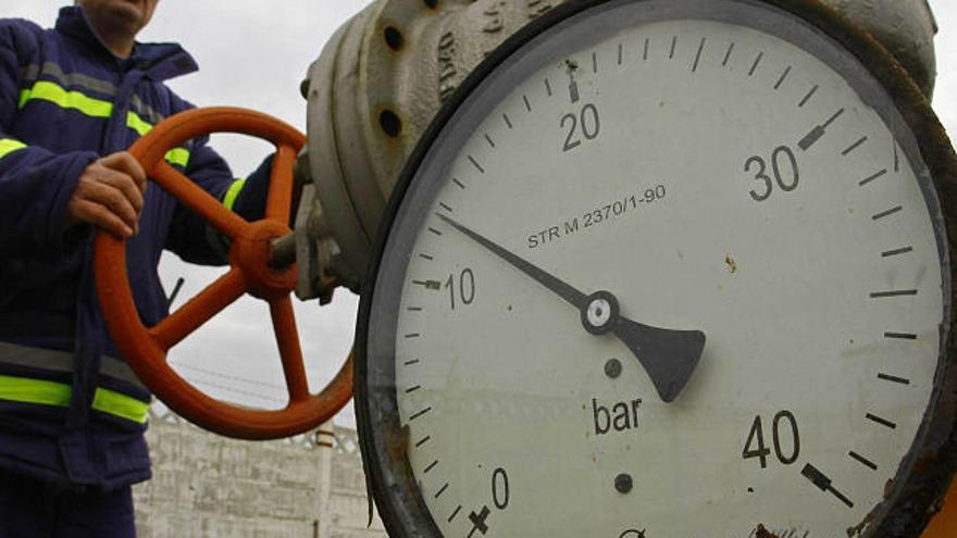 Un operario rumano manipula una llave de gas en la que se aprecia la baja presión del suministro.