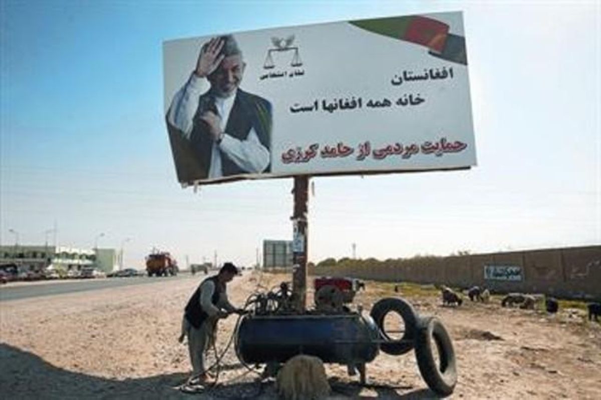 Un home afganès obre la seva parada de reparació de pneumàtics sota un cartell electoral de Karzai, ahir, a la localitat de Mazar-e sharif. Un home afganès obre la seva parada de reparació de pneumàtics sota un cartell electoral de Karzai, ahir, a la localitat de Mazar-e sharif.