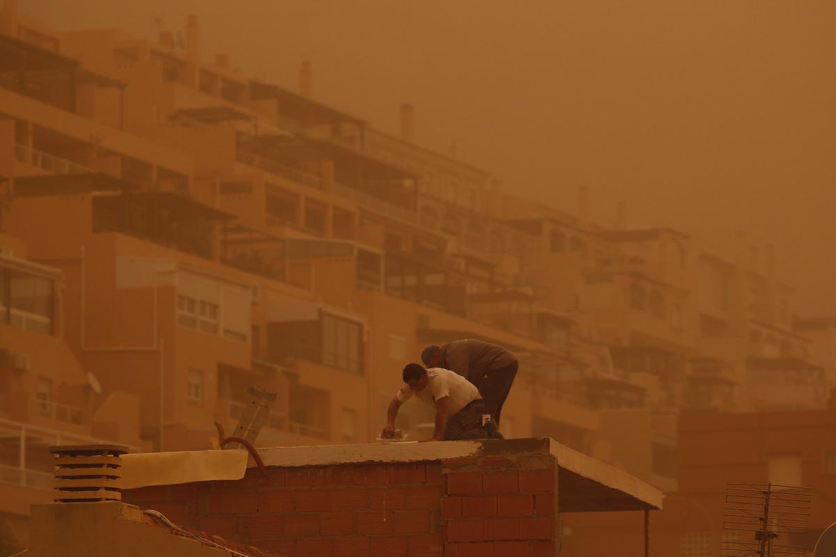 Unas personas trabajan en Aguadulce, Roquetas de Mar (Almería), bajo la calima.