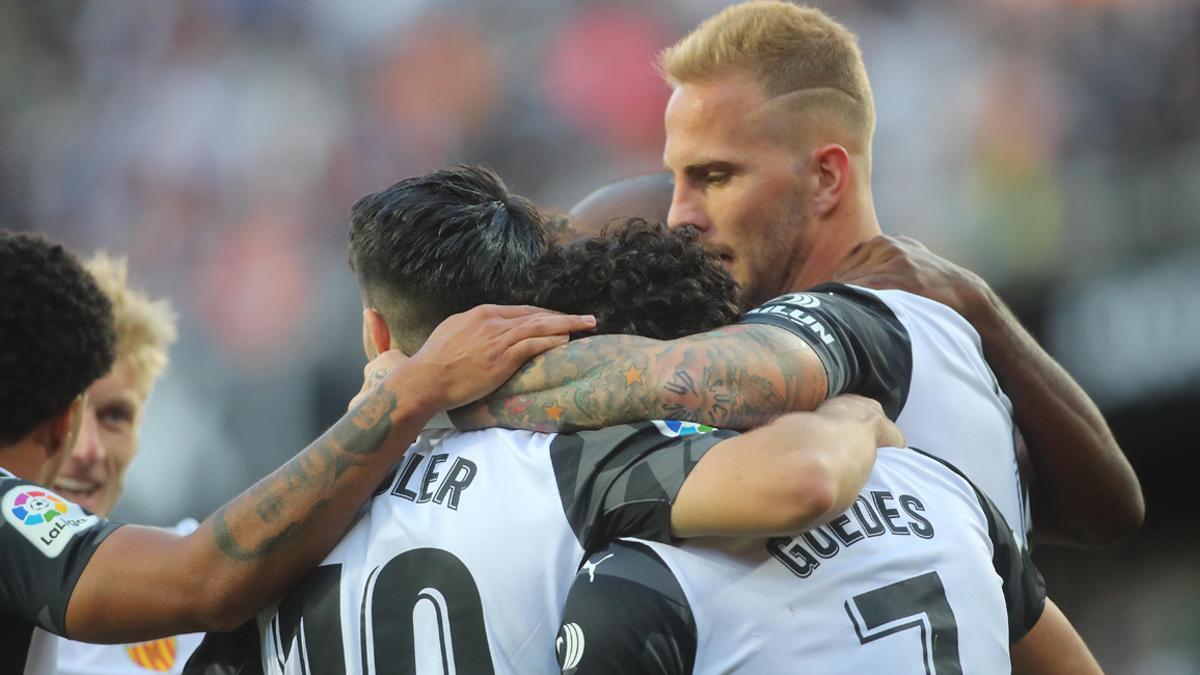 Racic, Soler y Guedes se abrazan tras anotar un gol