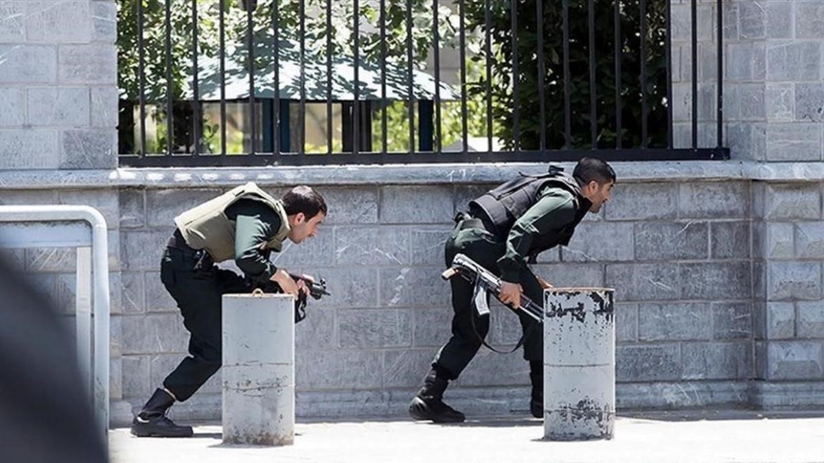 Miembros de las fuerzas de seguridad iranís se ponen a cubierto durante el ataque al Parlamento.