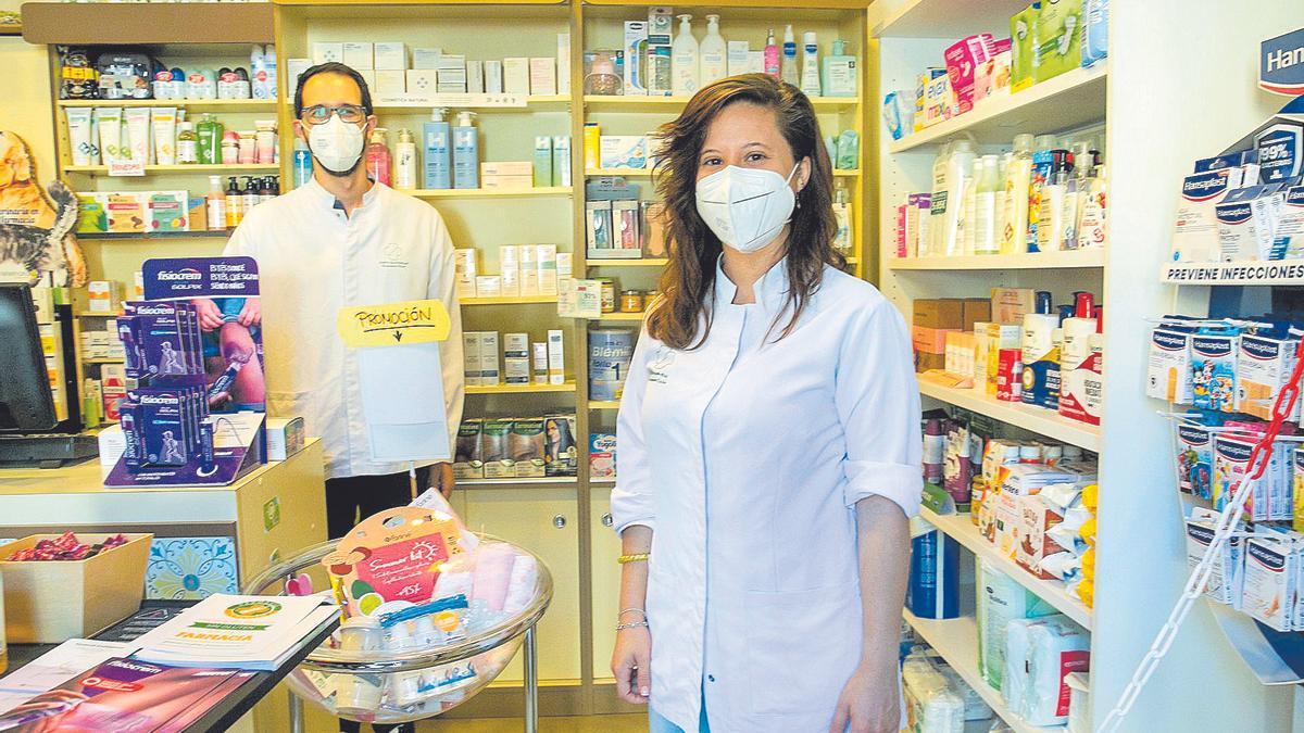Nuria Cascales y su pareja en la farmacia que regentan ambos.