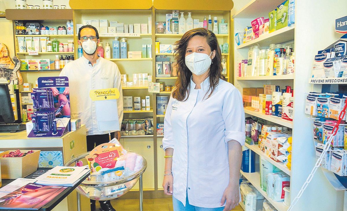 Nuria Cascales y su pareja en la farmacia que regentan ambos.