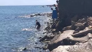 El suplicio de bañarse entre escombros en la playa de Dénia