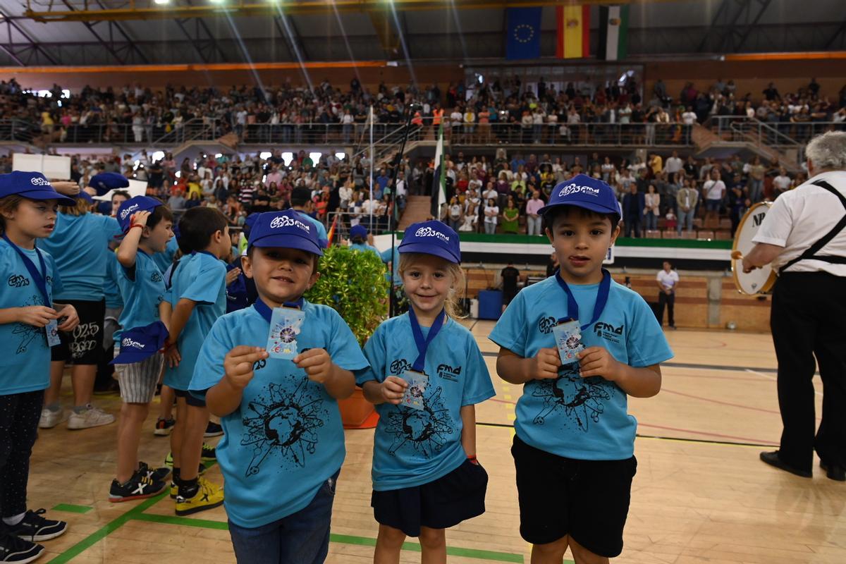 Tres escolares muestran orgullosos sus medallas.