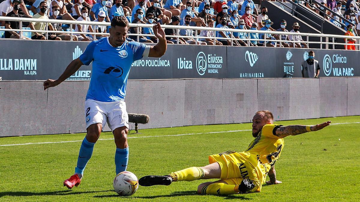 El lateral de la UD Ibiza Fran Grima intenta progresar con el esférico ante la acometida de un zaguero ovetense a ras de césped. | ZOWY VOETEN