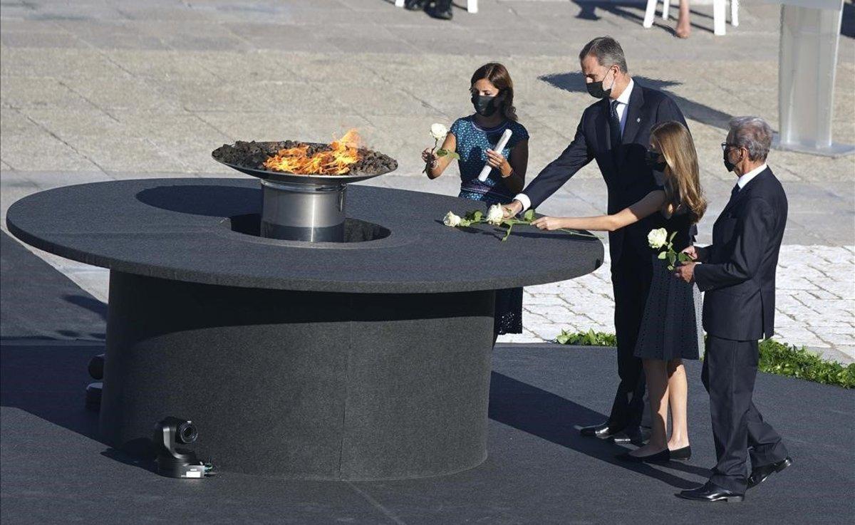 El rey Felipe VI, la princesa de Asturias, la jefa del servicio de Urgencias del Hospital Vall d’Hebron, Aroa López (izquierda), y Hernando Calleja (derecha), hermano del periodista José María Calleja, fallecido durante la pandemia, realizan una ofrenda floral en el pebetero del Patio de la Armería del Palacio Real. 