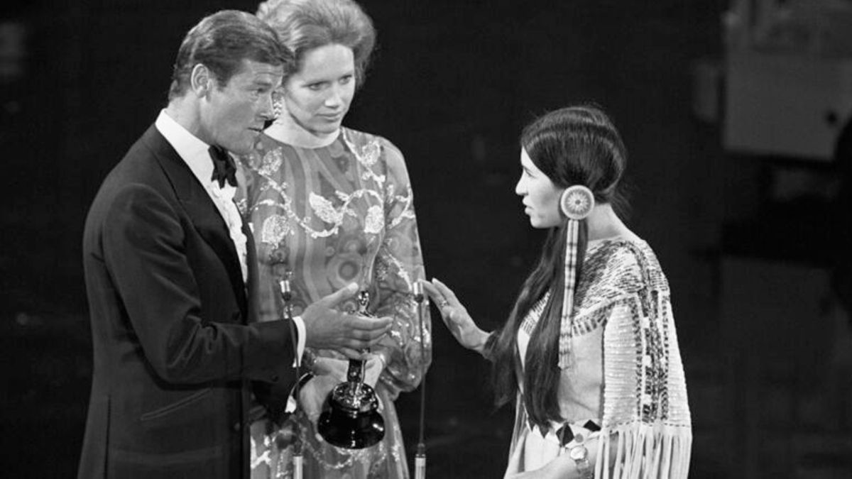 Sacheen Littlefeather recibe el Oscar para Marlon Brando de manos de Roger Moore y Liv Ullmann en los Oscars de 1973.