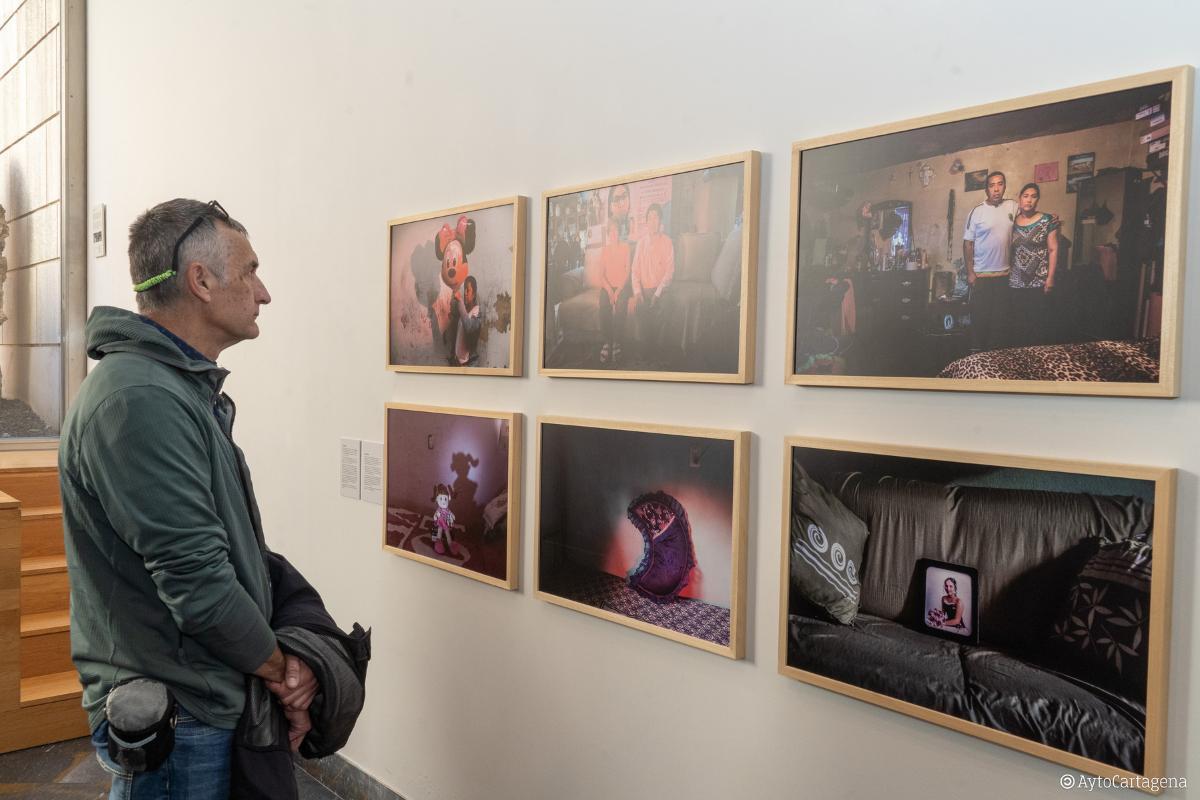 Una persona observa las fotografías durante la inauguración de la exposición.