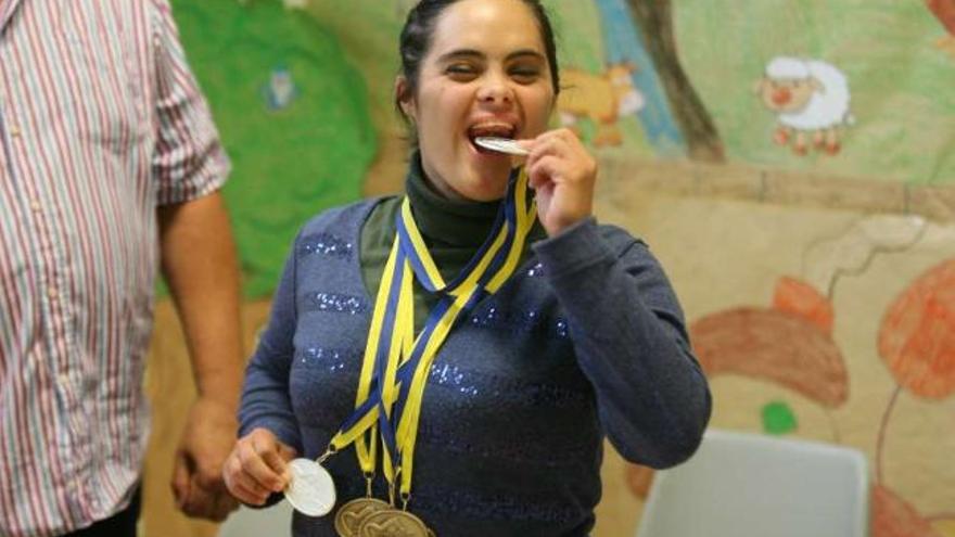 Loira Fernández muerde a lo Nadal una de sus cinco medallas, ayer en el Multiusos de Chapela. // De Arcos