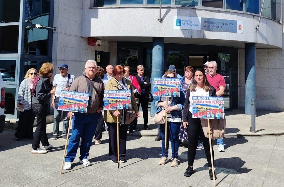 El grupo de afectrados por el cierre de Viaxes Loa, durante la protesta ante los Juzgados de Redondela.