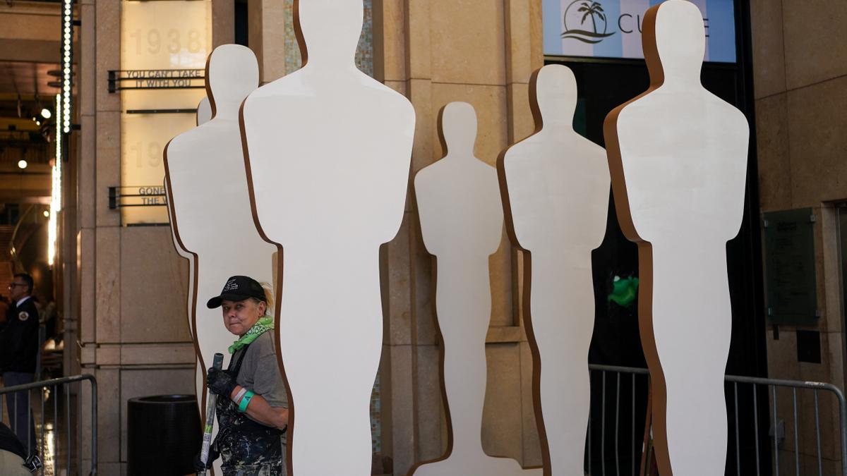 A worker paints statues along the red carpet in preparation for the Academy Awards in Los Angeles