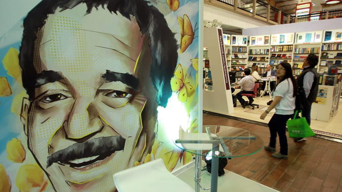 Una pareja pasa frente a una ilustración de Gabriel García Márquez en la Feria Internacional del Libro de Bogotá.