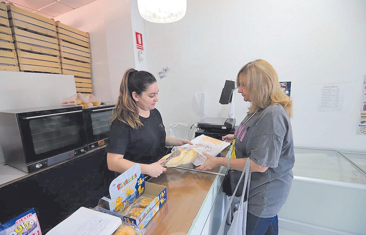 Una mujer compra el pan en una panadería de El Higuerón.