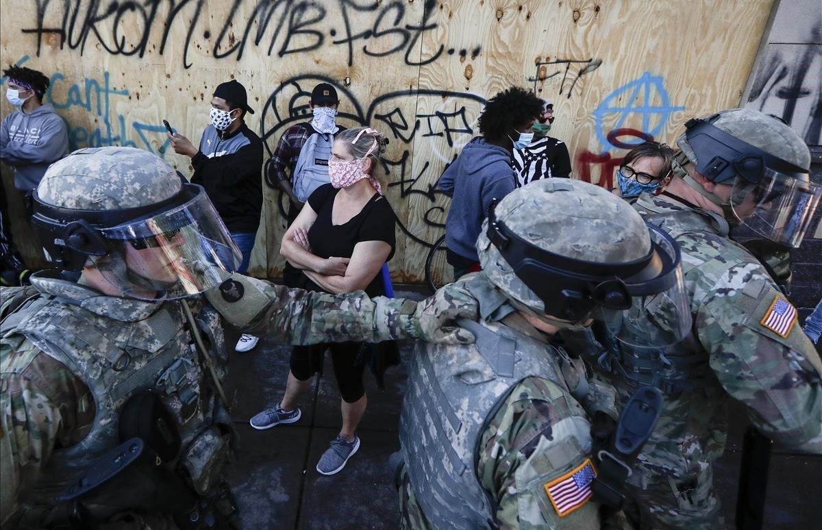 La Guardia Nacional regresa a su posición defensiva mientras los manifestantes dejan espacio en East Lake Street, Minneapolis.