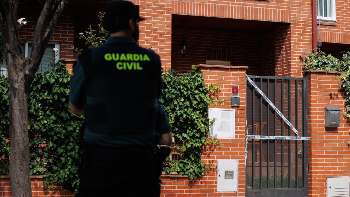 Un agente de la Guardia Civil enfrente de la vivienda donde ha tenido lugar el crimen.