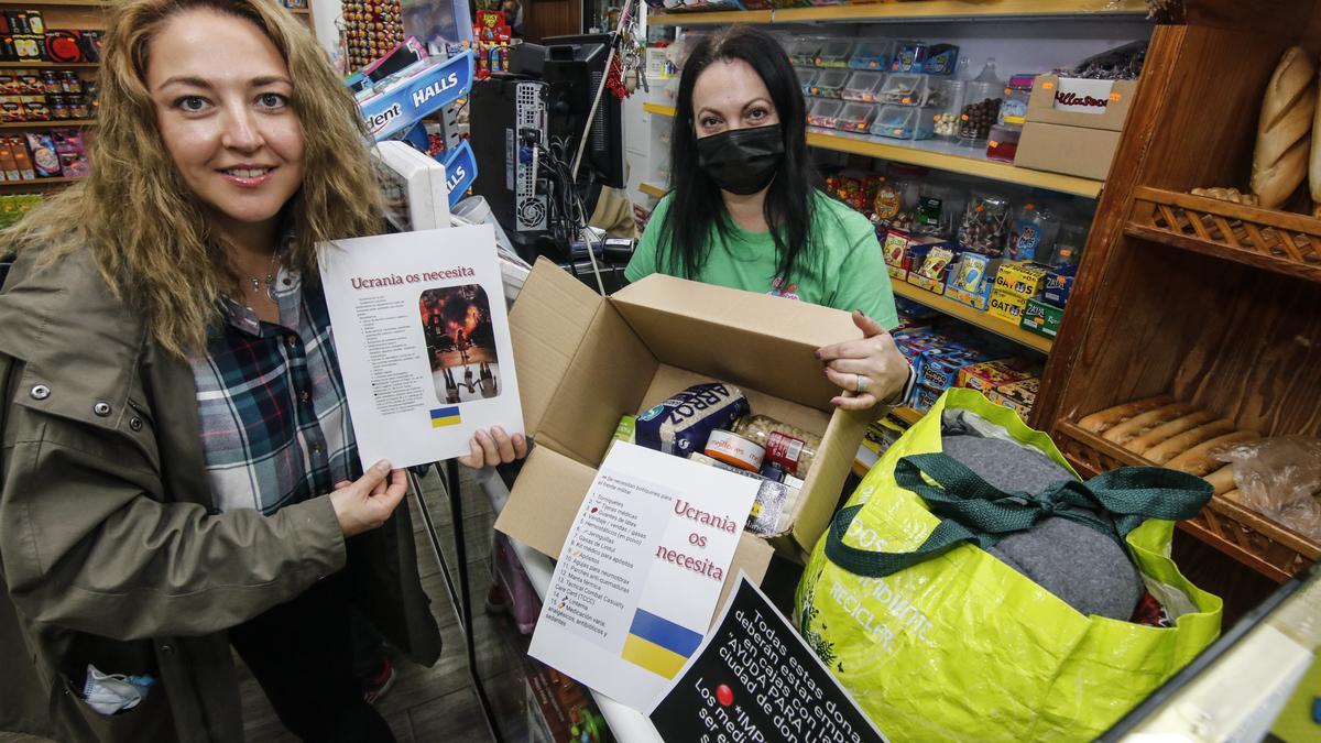 Khrystyna Mykulyak (en primer término) posa junto a Montaña, la dueña la tienda de Cáceres el Viejo, una de las que colabora en la campaña solidaria.