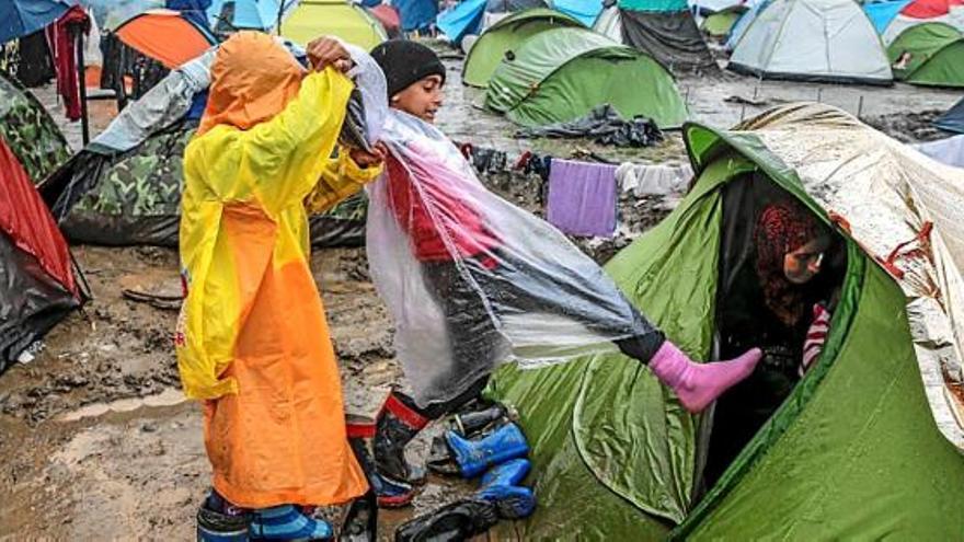 Dos infants, sota la pluja, en un camp de refugiats a Grècia