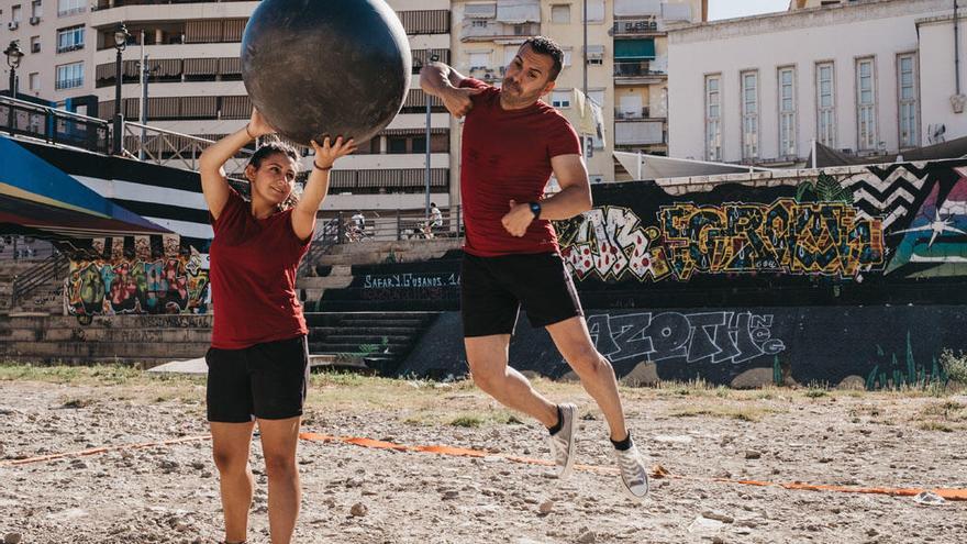 Dos jóvenes practican baloncodo en el cauce del Guadalmedina.