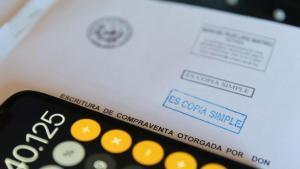 Una calculadora y una escritura de compraventa de una hipoteca