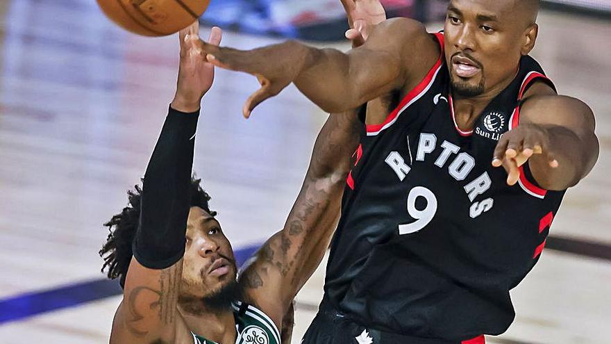 Serge Ibaka da un pase frente a Marcus Smart. | Efe