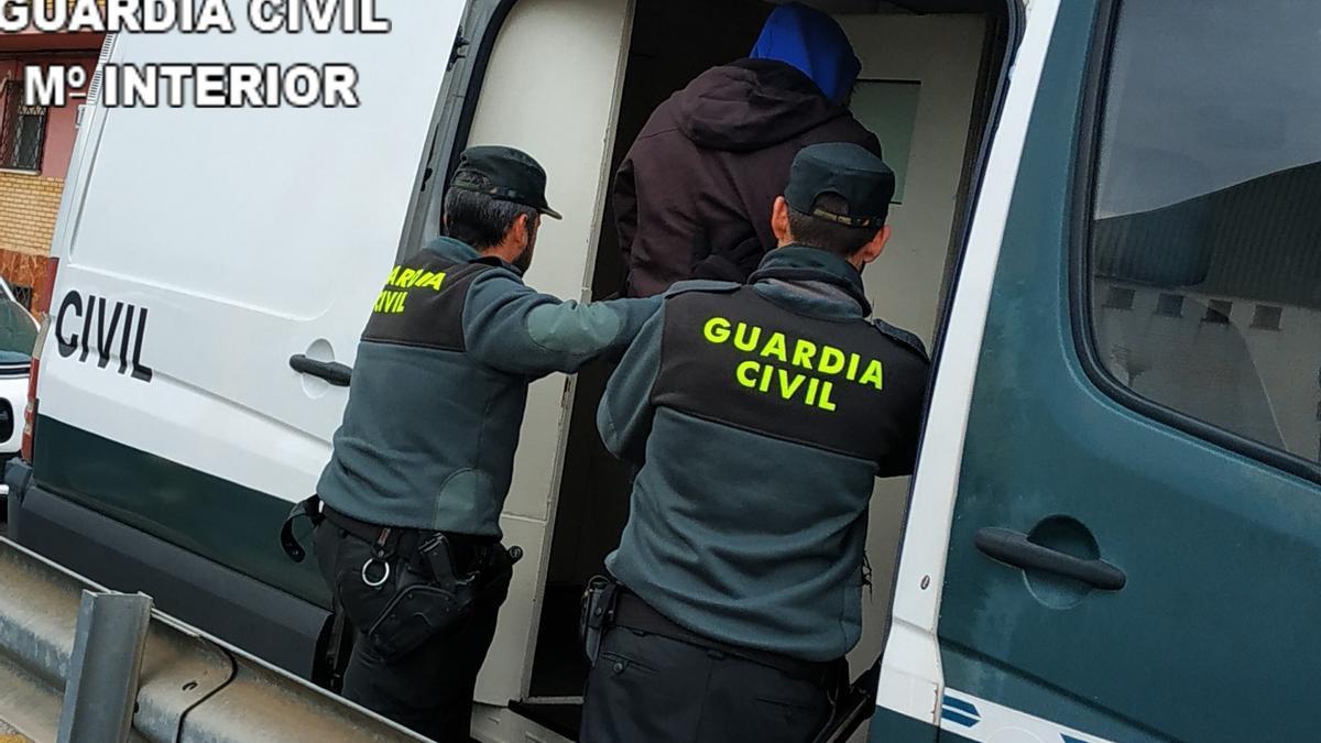 El detenido, conducido al furgón de la Guardia Civil por dos agentes.