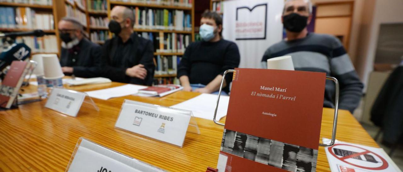 La portada del libro, ante los ponentes en la presentación. | VICENT MARÍ