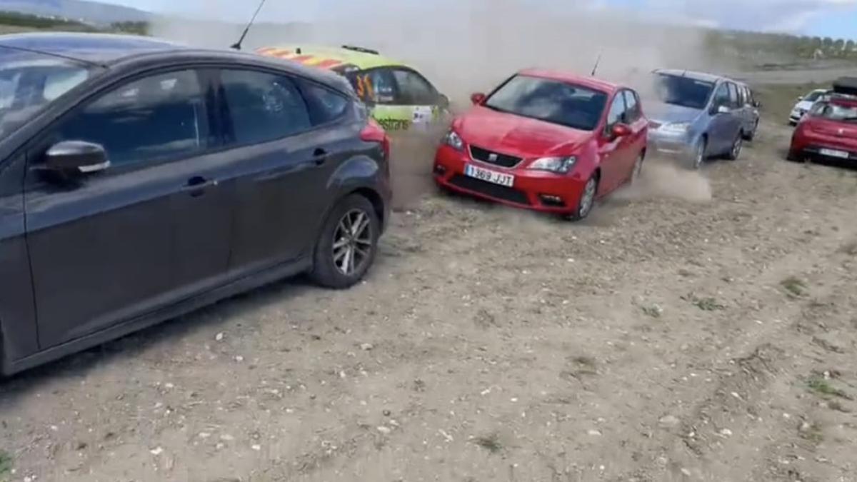 Momento del impacto de un coche de rali con vehículos estacionados.