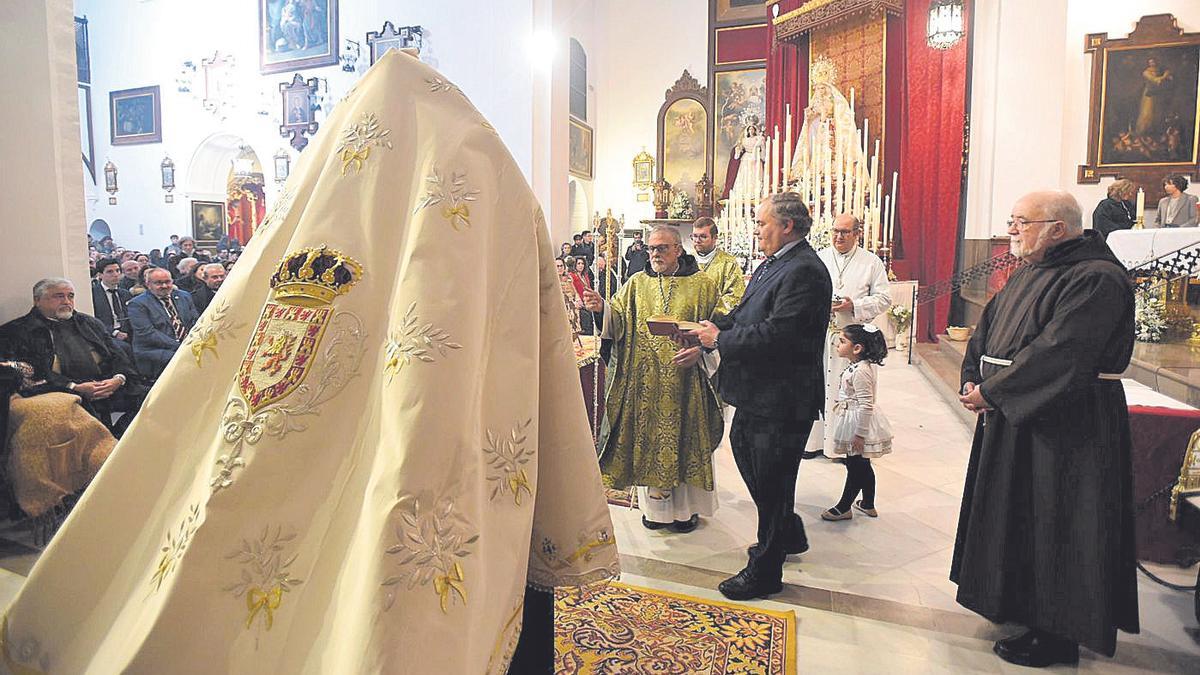 El consiliario de la hermandad, fray Francisco Martínez Melero, bendice el nuevo manto de la Virgen de la Paz.
