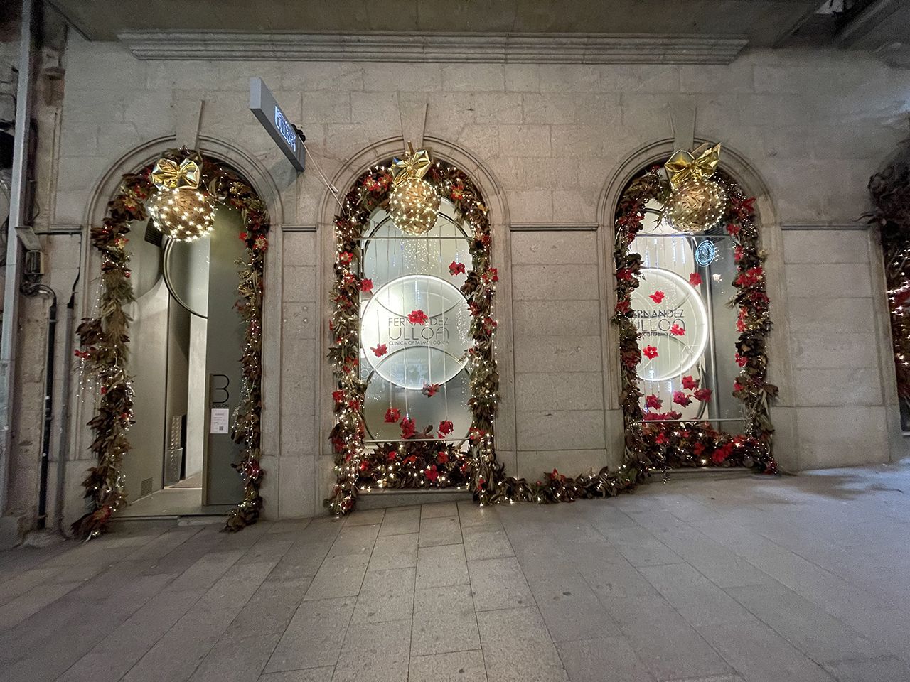 &quot;Navidad en la Clínica Fernández Ulloa&quot;. Composición de hojas de magnolio combinada con bolas navideñas y luces de fondo.