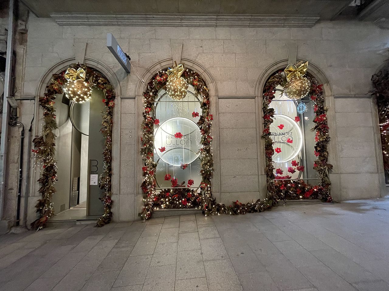 &quot;Navidad en la Clínica Fernández Ulloa&quot;. Composición de hojas de magnolio combinada con bolas navideñas y luces de fondo.