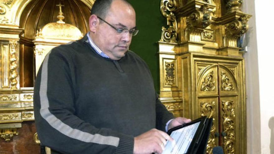 Andrés Pérez, de 39 años y cura de la iglesia de El Salvador de la localidad malagueña de Nerja, mira su tableta electrónica &quot;iPad&quot;.