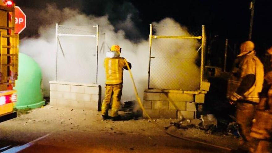 Los bomberos extinguiendo uno de los veinte contenedores incendiados en Novelda en la madrugada de este lunes